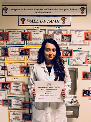 Marjan Khan with her award in front of the Natural Sciences Wall of Fame