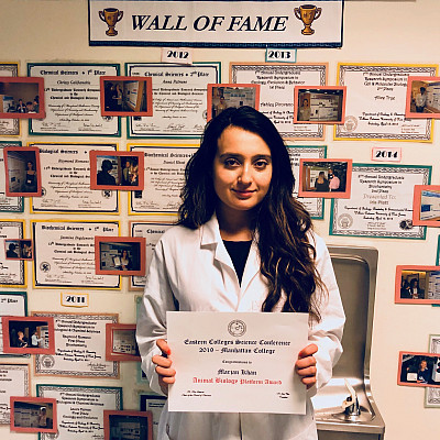 Marjan Khan with her award in front of the Natural Sciences Wall of Fame