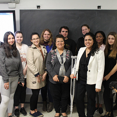 ﻿Students in Prof. Kazi Rahman's Diplomacy and Multiculturalism class pose for a photo with UN diplomat Meriem El Hilali (rig...