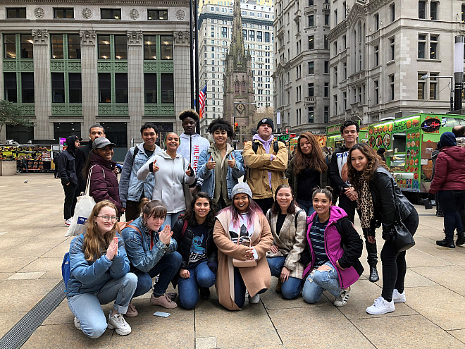 Students in the Financial District with Trinity Church in the background