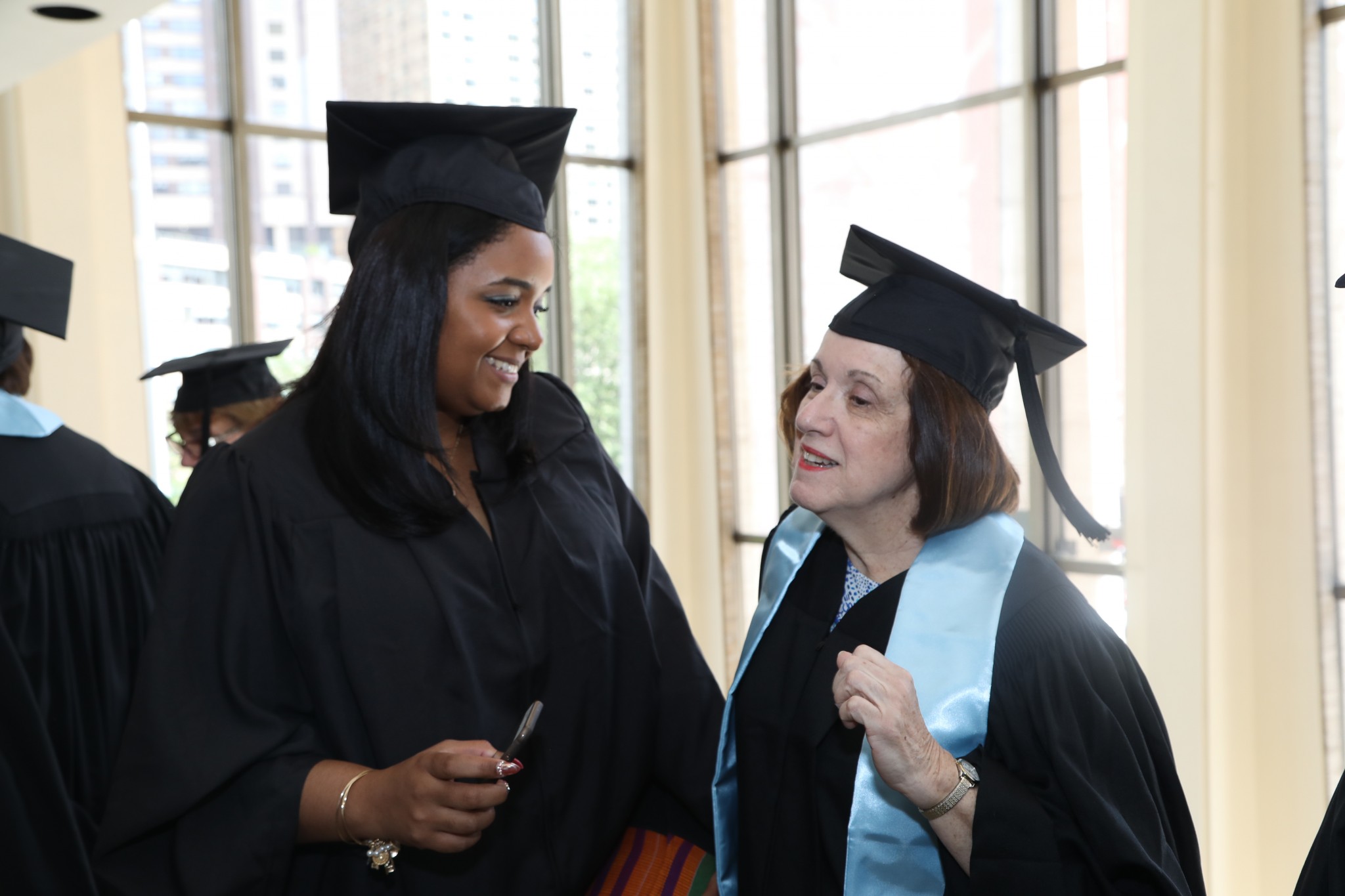 Faculty members talking to each other at Commencement 2017