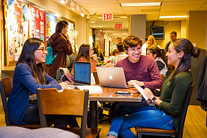 Students doing homework and talking to each other in Starbucks