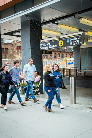 Students walking outside of the 72nd Street Subway Station towards the escalator