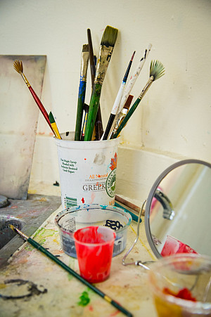 Art supplies on a table that is covered in paint