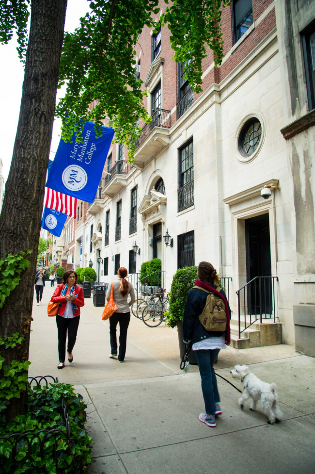 Woman walking her dog and people walking in different directions outside of Marymount Manhattan C...