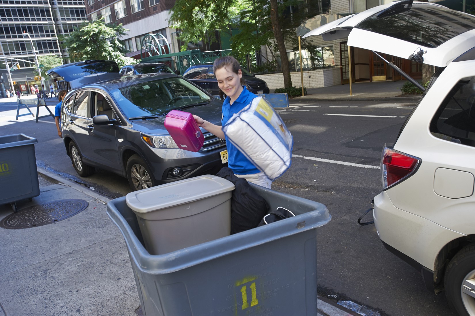 A resident advisor unloads a vehicle at check-in.