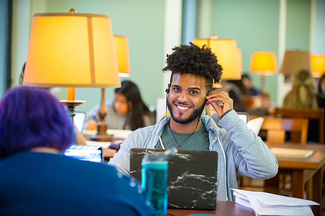 A smiling student taking a quick break from studying at the Shanahan library.