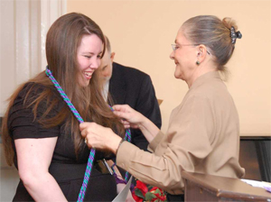 Twila Ligget, Ph.D., presents honors cords to a student during the Kappa Delta Pi Honor Society induction ceremony.