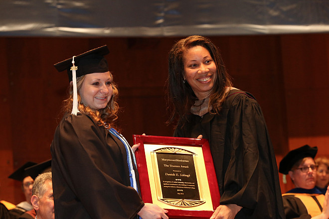 Chairperson of the Board of Trustees, Hope Knight '85, presents Danielle E. Schlough with the Trustees' Award