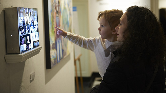 Viewers interacting with Carley Eiten's lightbox in The Hewitt Gallery of Art
