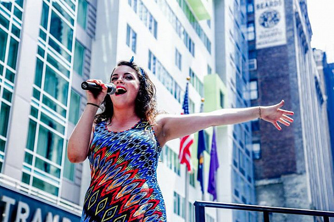 Alumnus Melissa Rose Hirsch singing on a float during the New York City Pride Parade.